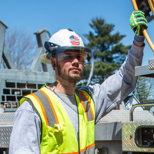 A construction worker wearing a safety helmet with the TruSpan universal face shield attached, providing full-face protection.