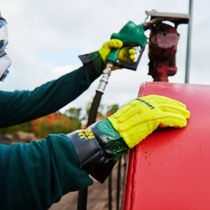 person using the 7310 gloves at a industrial gas pump holding the nozzle