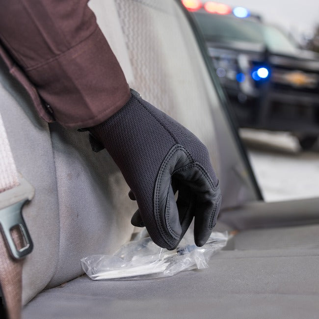 Officer wearing 2137 gloves picking up a needlestick 