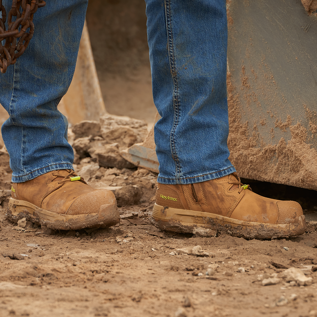 Construction worker standing in Xtend tan 8-inch safety boots on a step. 