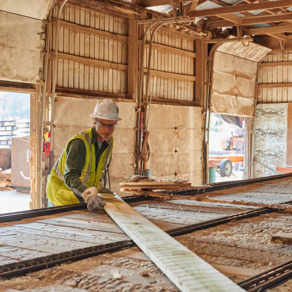Worker using HexArmor Bandit safety gloves in a paper mill.